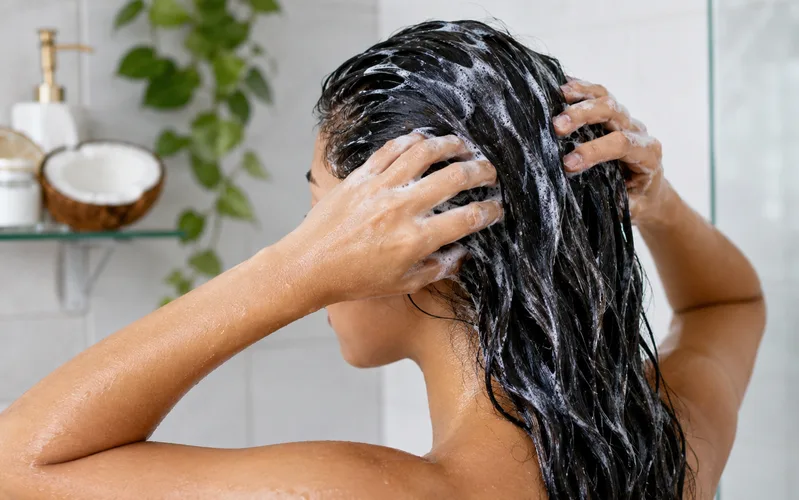Thoa dầu gội lên phần tóc đã ủ trước khi thêm nước giúp loại bỏ dầu dừa dễ dàng hơn